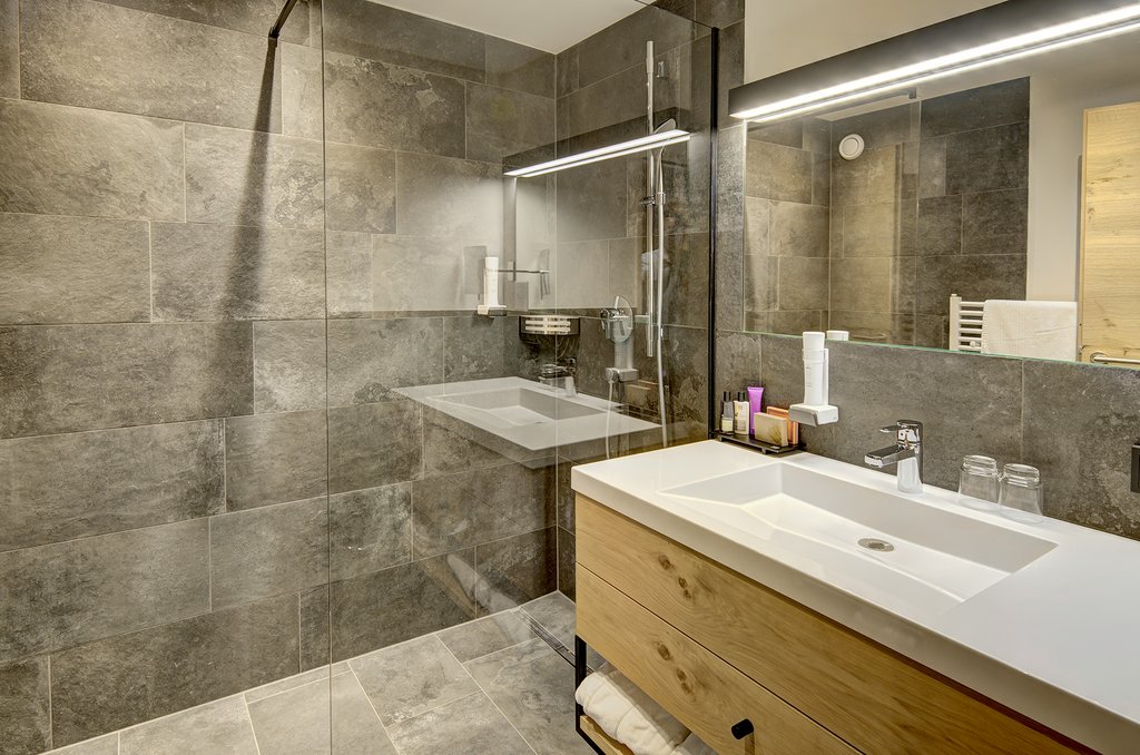 Badezimmer im Vier-Sterne Supe­rior Hotel Gut Brandlhof mit warmer Ausstahlung