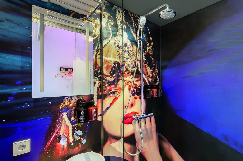 Duschbereich mit Wandbild und Grohe-Produkten im BUNK Hotel Utrecht