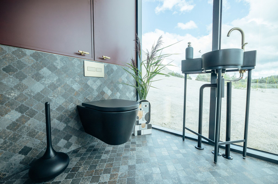 Badezimmer mit Toilette und Waschbecken des "Golden House" von Stu­dio ÖÖD House mit Produkten von AXOR